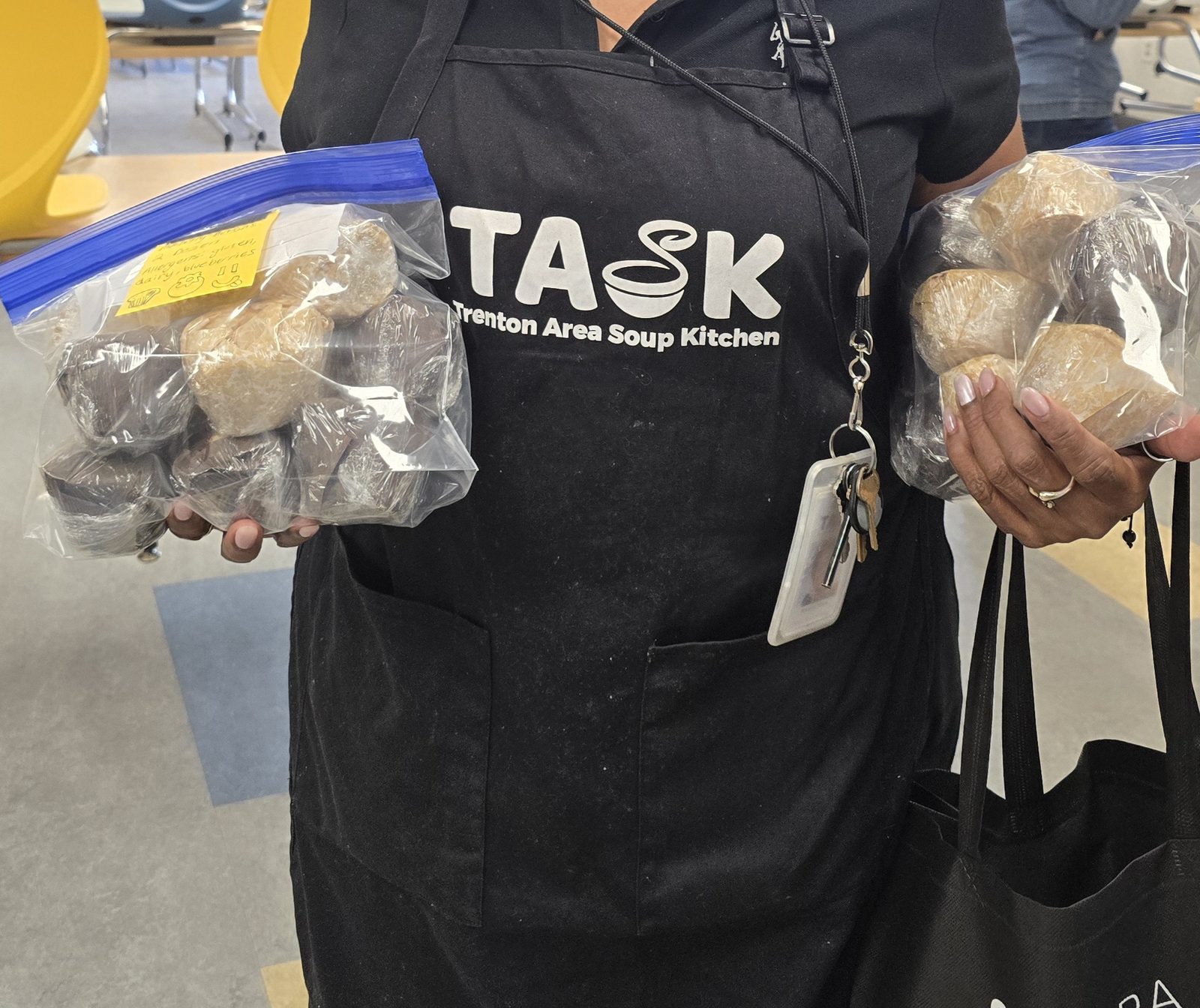 Trenton Area Soup Kitchen staff receiving bags of home-baked muffins, labeled with allergen information